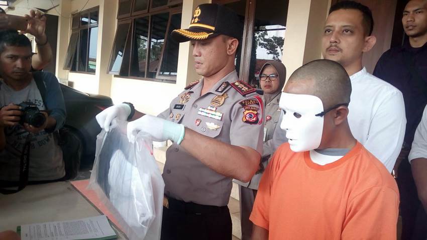 Kapolres Garut AKBP Budi Satria Wiguna menunjukan pelaku pencabulan terhadap anak kandungnya di Garut (Liputan6.com/Jayadi Supriadin)