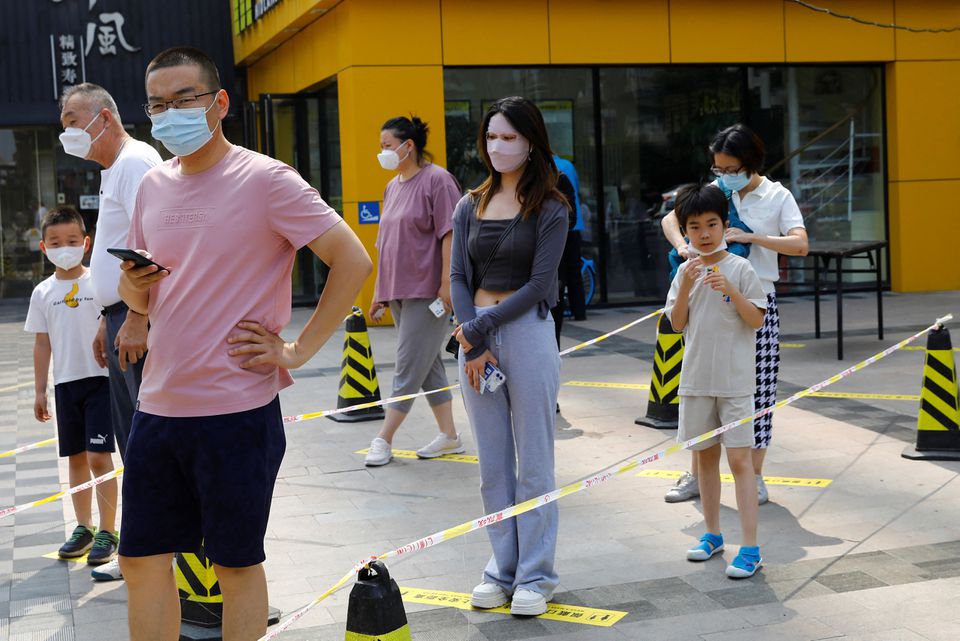 People line up for nucleic acid testing at a mobile testing booth, following the coronavirus disease (COVID-19) outbreak, in Beijing, China June 10, 2022. REUTERS/Tingshu Wang